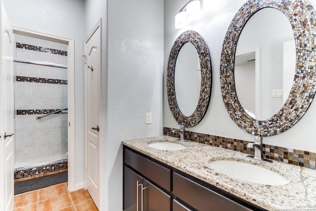 bathroom featuring tile patterned flooring, vanity, and a shower with door