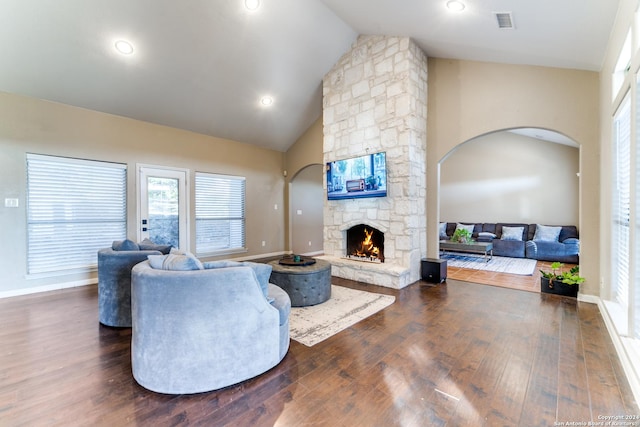 living room featuring a stone fireplace, dark hardwood / wood-style flooring, and high vaulted ceiling