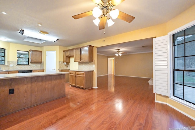 kitchen featuring decorative backsplash, dark hardwood / wood-style flooring, and crown molding