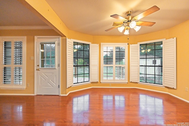 interior space featuring ceiling fan, wood-type flooring, and ornamental molding