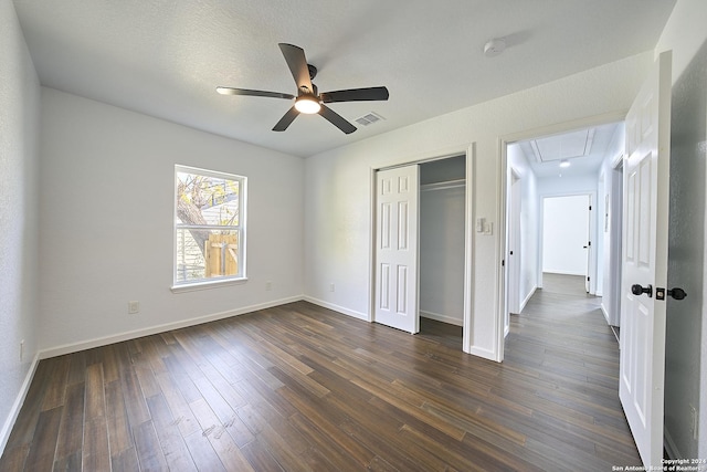 unfurnished bedroom featuring ceiling fan, dark hardwood / wood-style floors, a closet, and a textured ceiling