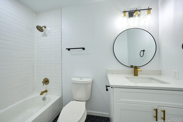 full bathroom featuring tiled shower / bath, vanity, and toilet