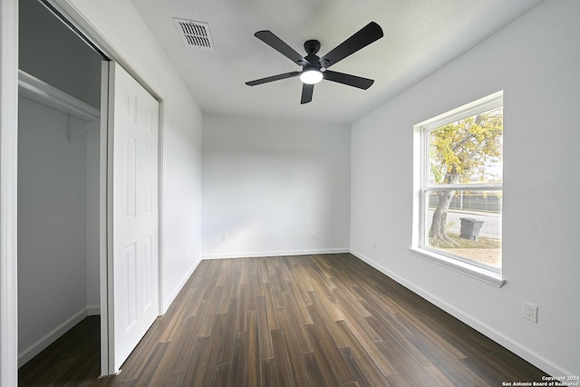 unfurnished bedroom featuring dark hardwood / wood-style floors, ceiling fan, and a closet