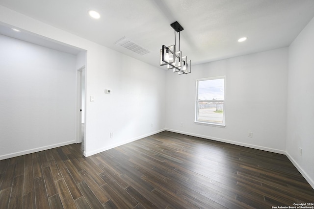 unfurnished room with a chandelier and dark hardwood / wood-style flooring