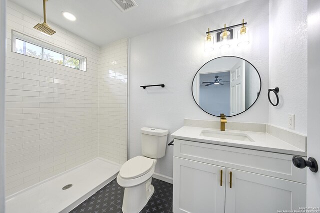 bathroom featuring vanity, toilet, and tiled shower
