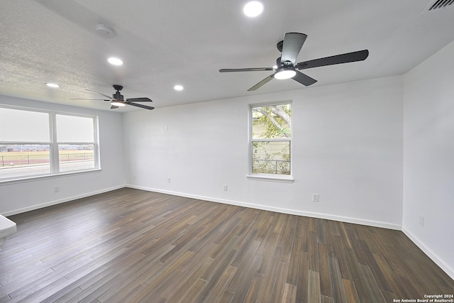 empty room with dark hardwood / wood-style floors and a textured ceiling