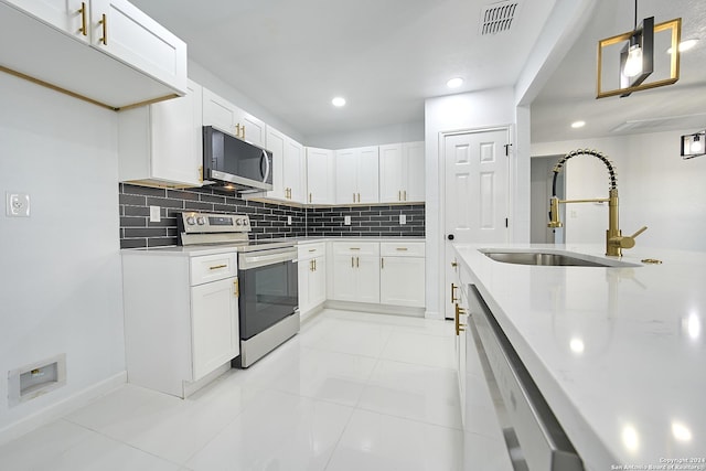 kitchen featuring white cabinetry, hanging light fixtures, stainless steel appliances, and sink