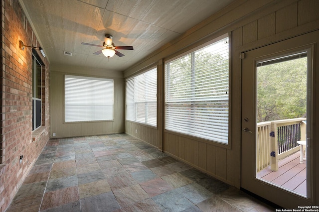 unfurnished sunroom with ceiling fan