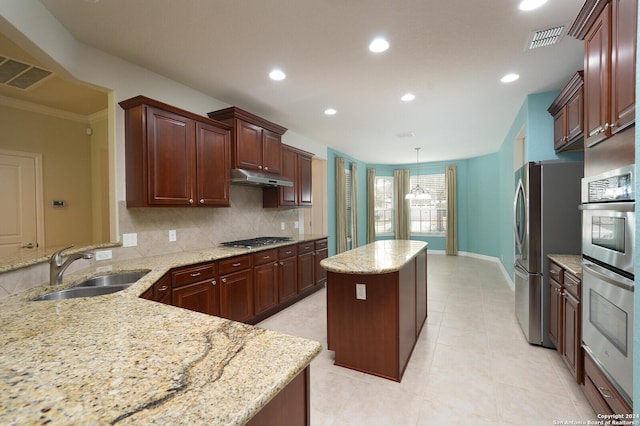 kitchen featuring light stone countertops, a center island, stainless steel appliances, and sink