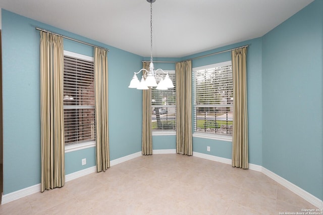 unfurnished dining area with an inviting chandelier