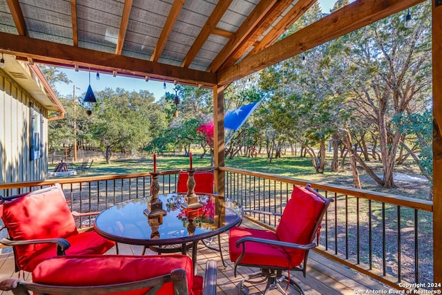 wooden terrace with outdoor dining area and a yard