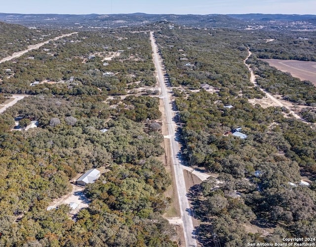 drone / aerial view featuring a wooded view