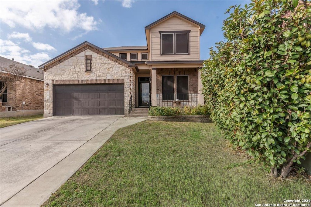 view of front of property featuring a front yard and a garage