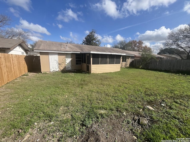 back of house featuring a sunroom and a yard