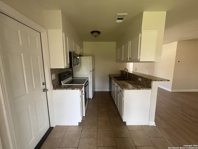 kitchen featuring kitchen peninsula, dark hardwood / wood-style flooring, white cabinets, and white electric range oven