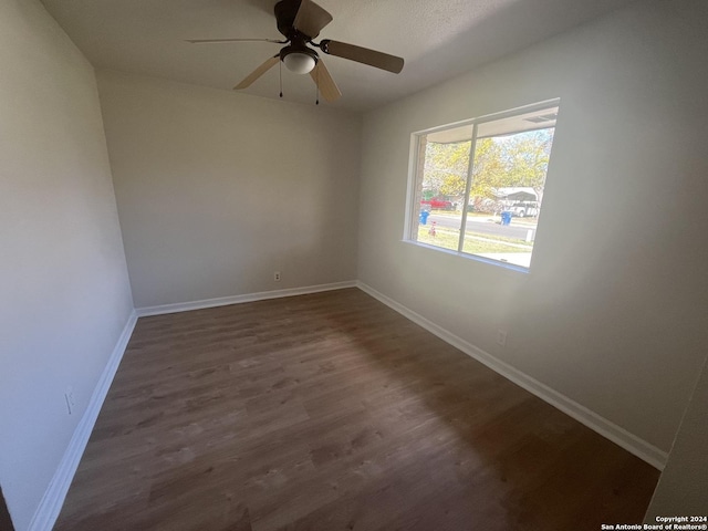 unfurnished room featuring dark hardwood / wood-style flooring and ceiling fan