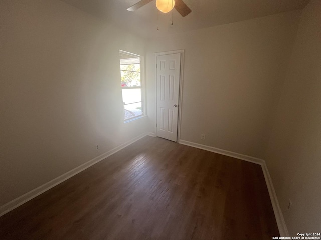 spare room with ceiling fan and dark wood-type flooring