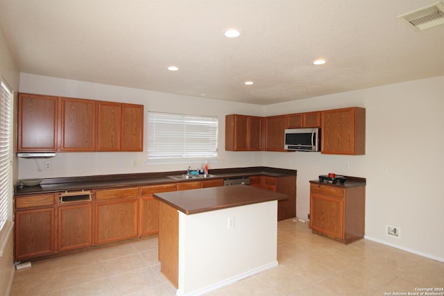 kitchen with a center island, sink, light tile patterned floors, and stainless steel appliances