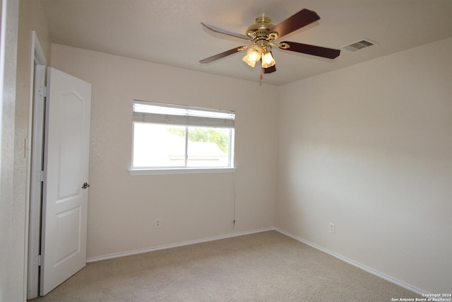 spare room with ceiling fan and light colored carpet