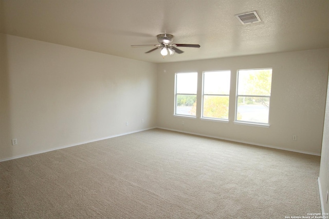 spare room featuring ceiling fan and light carpet