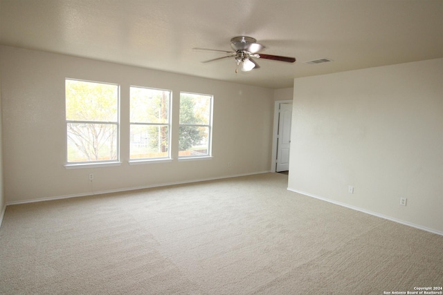 carpeted spare room featuring ceiling fan