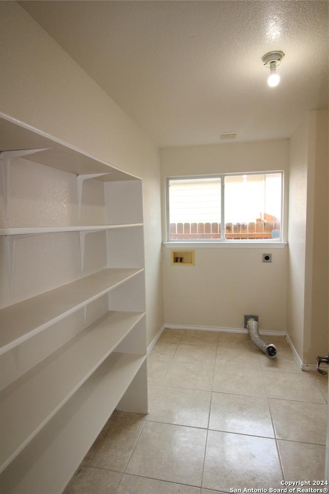 laundry area featuring washer hookup, light tile patterned floors, and electric dryer hookup