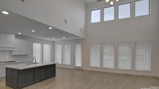 kitchen featuring visible vents, light wood-style flooring, light countertops, stainless steel gas cooktop, and a sink