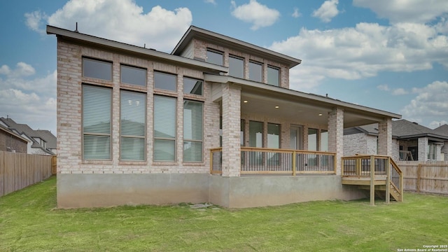 back of house with a lawn and fence