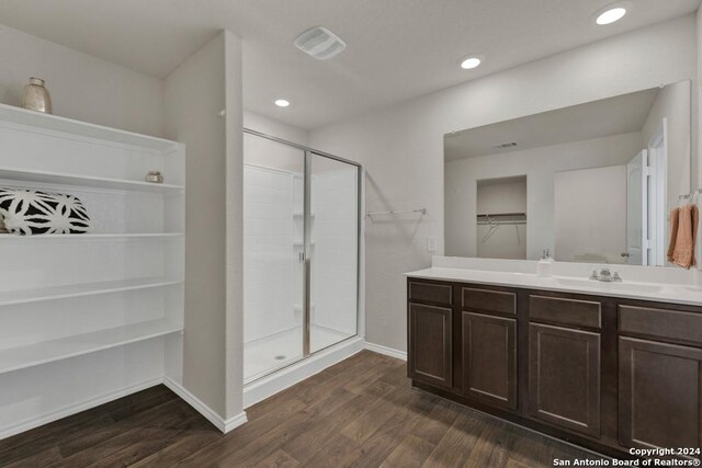 bathroom with a shower with door, vanity, and hardwood / wood-style floors