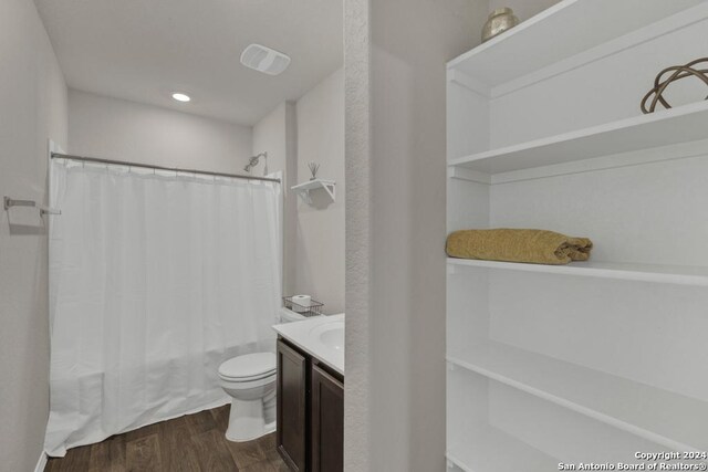 full bathroom with vanity, wood-type flooring, toilet, and shower / tub combo with curtain