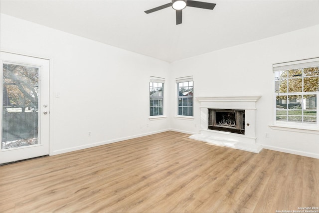 unfurnished living room with a wealth of natural light, ceiling fan, and light hardwood / wood-style floors