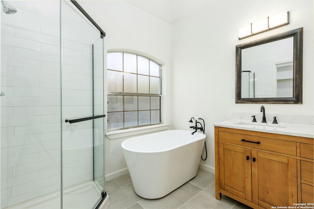 bathroom with tile patterned floors, vanity, and shower with separate bathtub