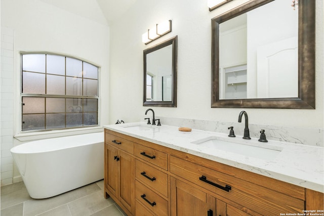 bathroom with tile patterned floors, vanity, and a tub to relax in