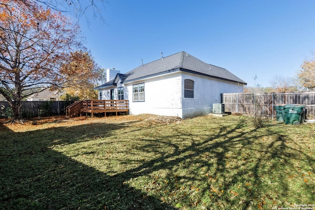 back of house featuring central AC unit, a lawn, and a wooden deck