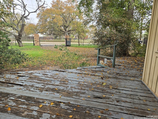 wooden deck featuring a lawn