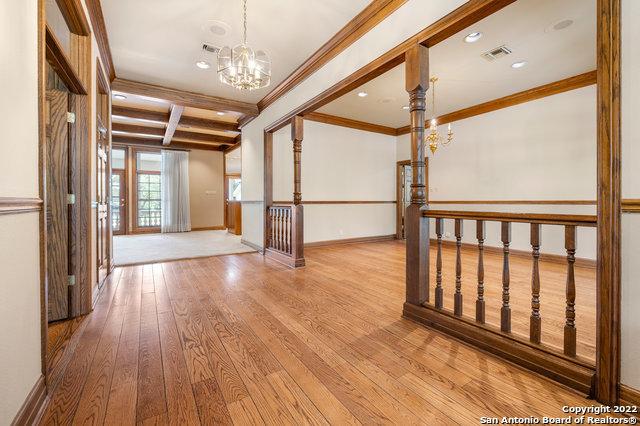 spare room with beam ceiling, crown molding, light hardwood / wood-style flooring, and a notable chandelier