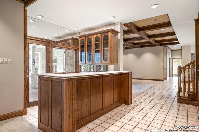 kitchen featuring beamed ceiling, light tile patterned floors, ceiling fan, and coffered ceiling