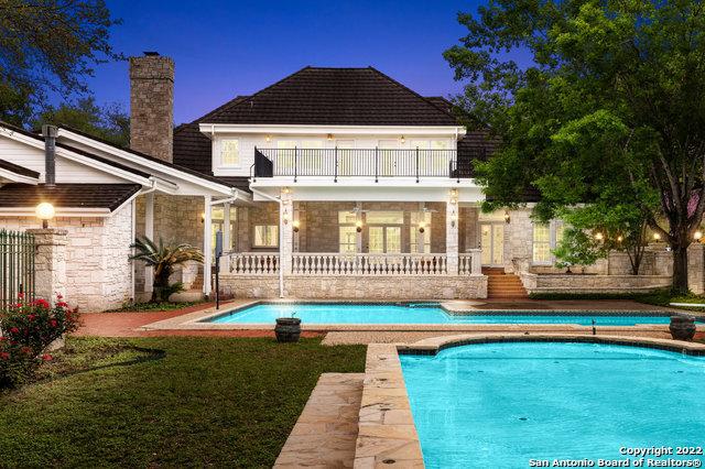 rear view of house featuring a yard and a balcony