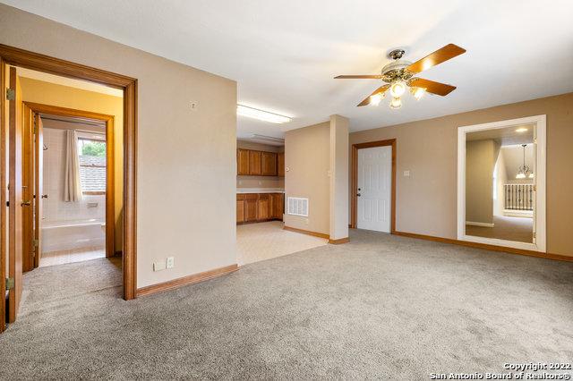 unfurnished living room featuring ceiling fan and light carpet