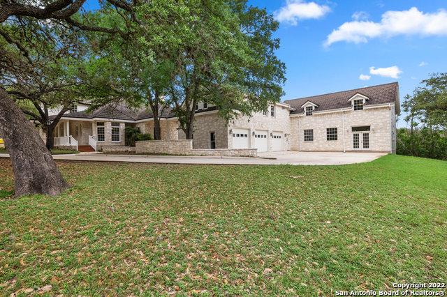 rear view of property featuring french doors, a yard, and a garage