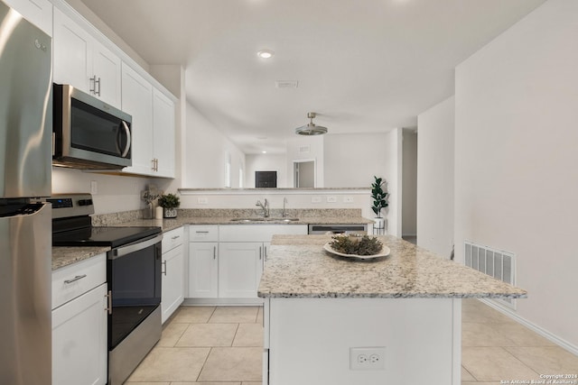 kitchen featuring white cabinets, sink, a kitchen island, and stainless steel appliances