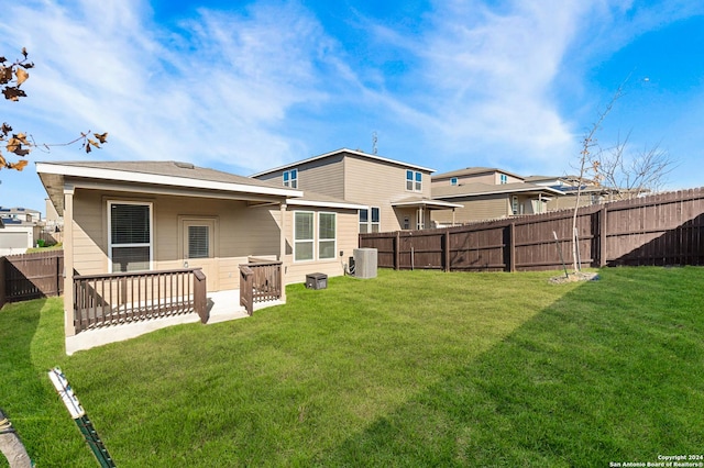 rear view of property with ac unit and a yard