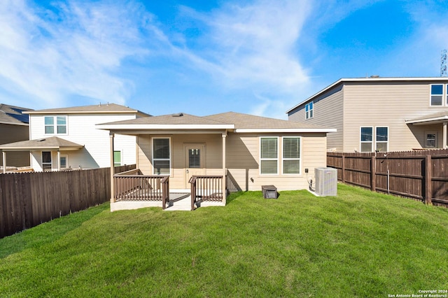 back of house with a lawn and central AC