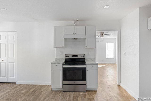 kitchen featuring white cabinets, light wood-type flooring, stainless steel electric range oven, and backsplash