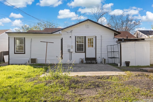 rear view of property with a yard, a patio, and central AC