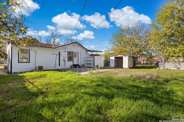 back of property featuring a shed and a yard