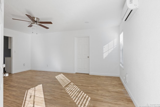 empty room with ceiling fan, light hardwood / wood-style floors, and a wall mounted air conditioner