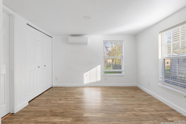 interior space with wood-type flooring and a wall mounted AC