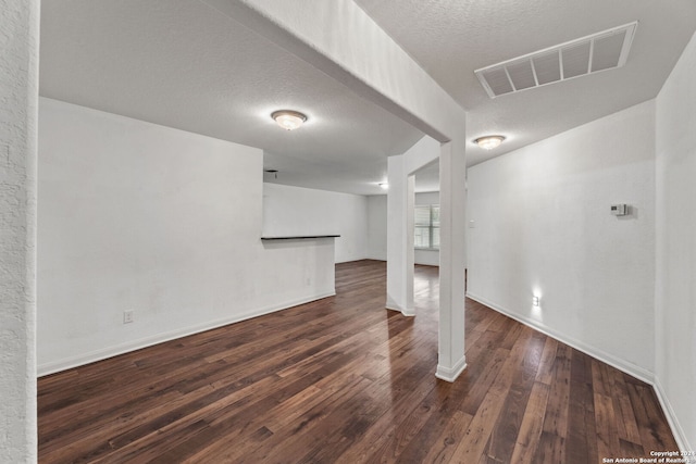 interior space with a textured ceiling and dark wood-type flooring