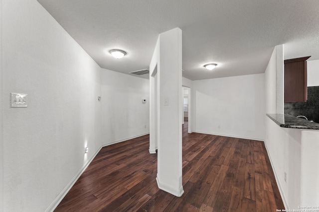 basement featuring dark hardwood / wood-style flooring and a textured ceiling